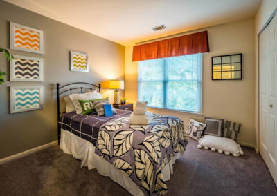 Spectacular model bedroom with carpeted flooring and medium-sized window in The Meadows apartments